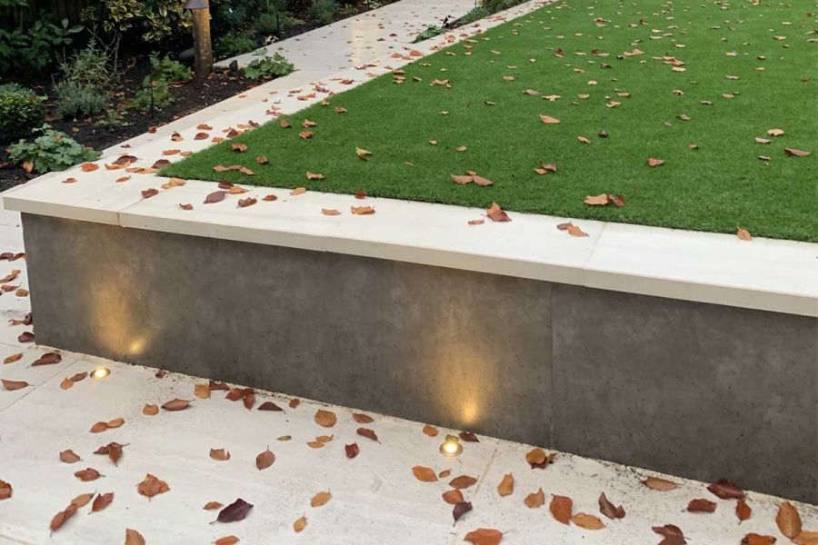 Vulcano Ceniza Luxury external cladding faces retaining wall of lawn, topped with Faro porcelain coping. Design by Waratah Gardens.