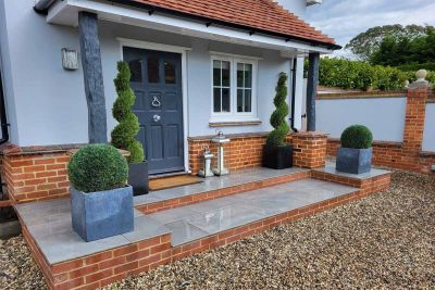 Alongside paving steps, Wet Florence Storm Porcelain Paving leads up to the front door, with topiary planting adorning either side.***D Honour & Sons, www.honourlandscape.co.uk
