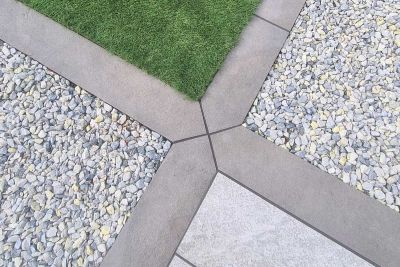 4 Steel Grey porcelain planks with mitred ends form a cross, edging gravel, grass and paving squares. By Aspen Landscape Design.***Aspen Landscape Design & Build,  www.aspenlandscapeglasgow.co.uk