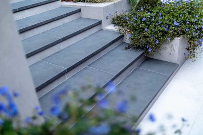 Steel Grey porcelain steps with 20mm downstand, next to DesignClad-faced stepped planters. Design by Gardens of the Future. ***Gardens Of The Future, www.gardensofthefuture.co.uk
