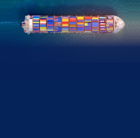 Container ship with multi-coloured cargo see from above, next to How did we calculate our carbon footprint.