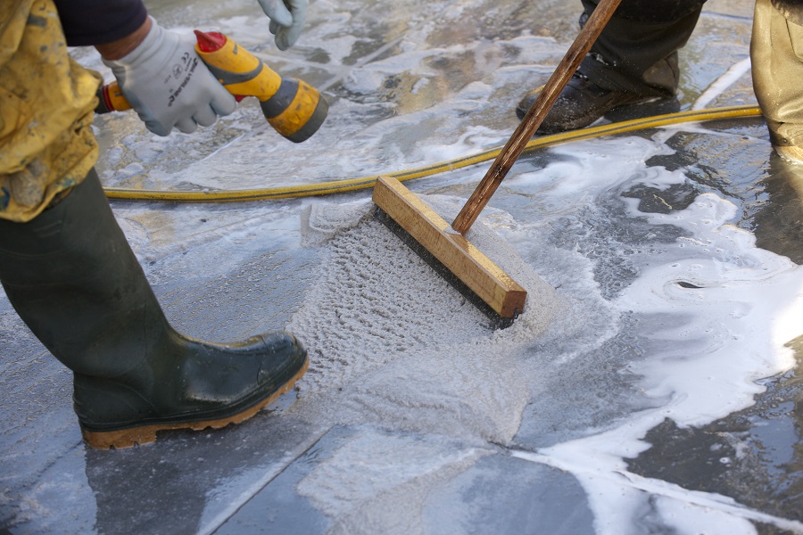 Brush-in mortar being laid with broom and hose in winter