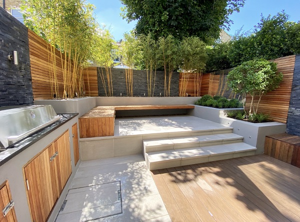 Garden paving ideas with DesignBoard traditional edged on 2 sides with urban grey porcelain. Downstand steps up to seating area.