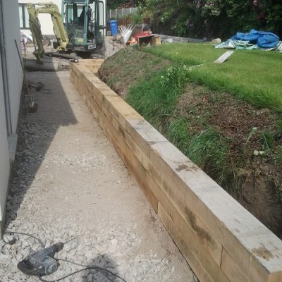 Unpaved path with timber sleepers put in as retaining wall for higher ground. 