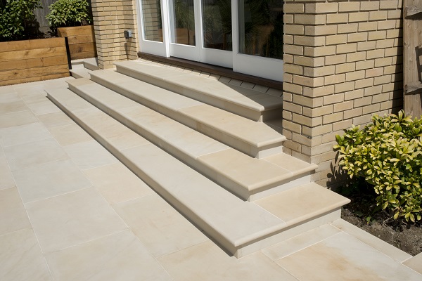 4 Harvest sawn sandstone bullnose steps descend from french doors to patio. 