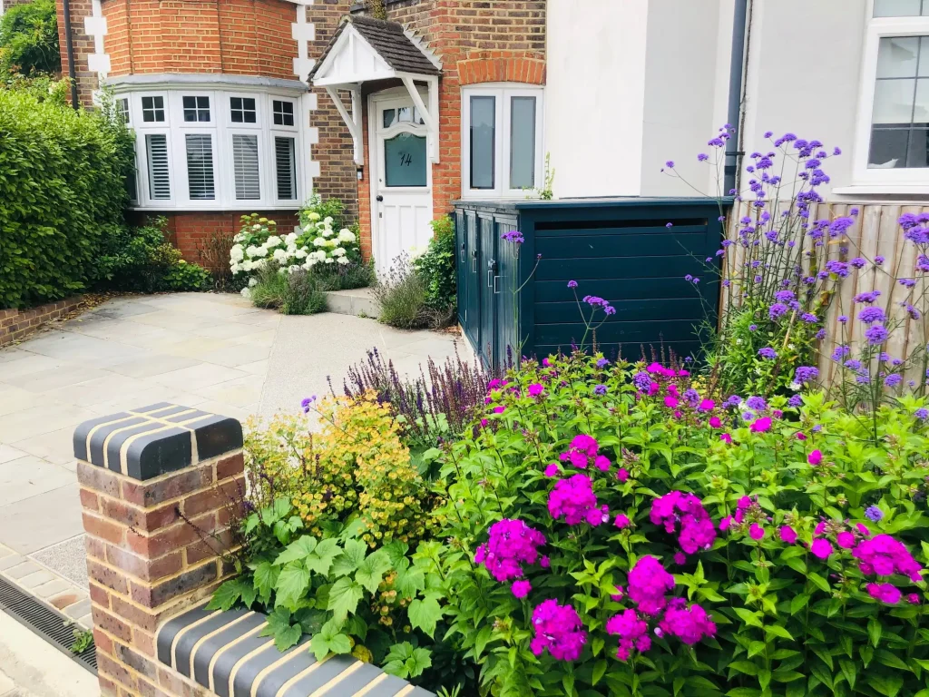 Period brick house with small Kandla Grey Indian Sandstone driveway in front of front door. Covered bin shed to right. 