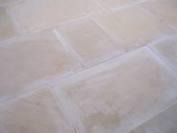Close view of Harvest sawn sandstone with cement stains along the edge of every slab. 