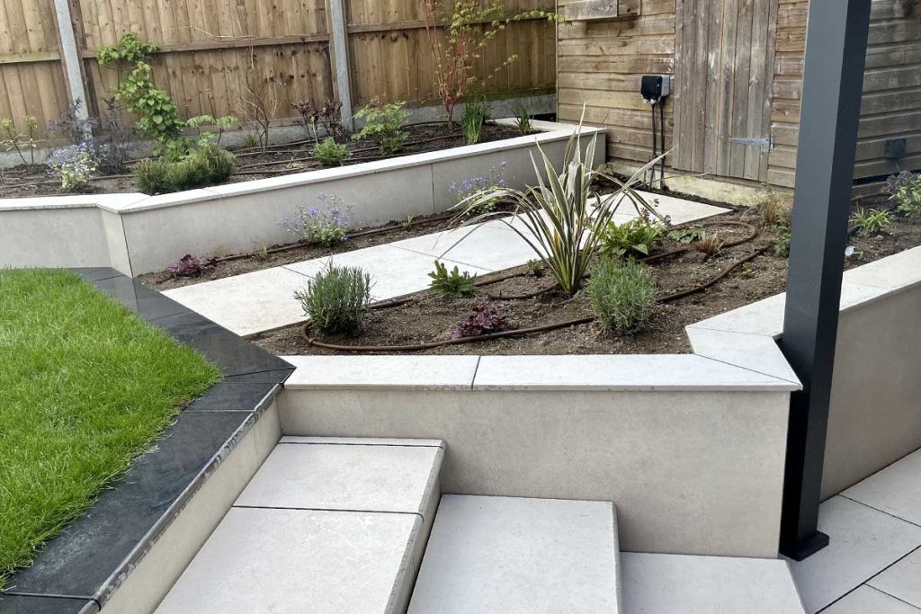 Steps and raised beds in Florence White porcelain paving, with matching coping stones. 