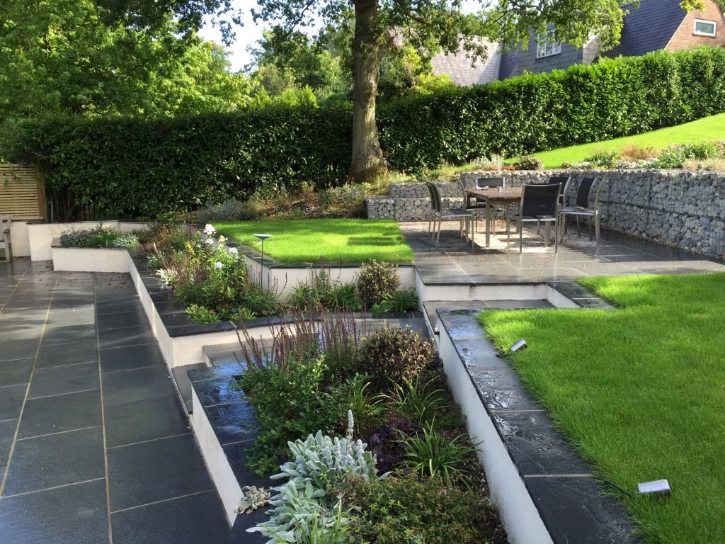 Wide terrace with grey-blue granite and black limestone coping, white rendered walls and gabions.