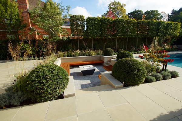 Sunken seating area in large patio of Heath sawn sandstone, with topiary features.