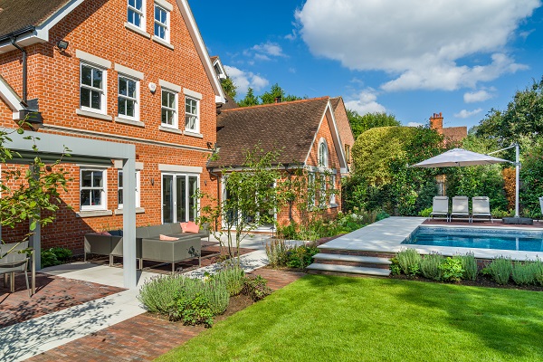 Wide patio in Dove Grey sandstone with inset Antique red clay pavers. Pergola and steps to swimming pool. 