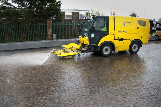 Street cleaning machine blasts water onto paving jointed with GftK mortar.
