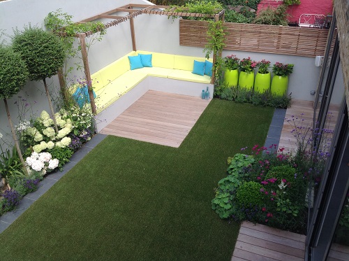 Render of garden showing lawn, decking, seating corner, pergola and porcelain paving.