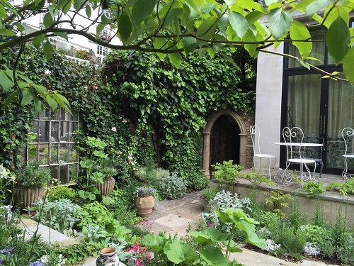 Small town garden with reclaimed Yorkstone paving and raised patio.