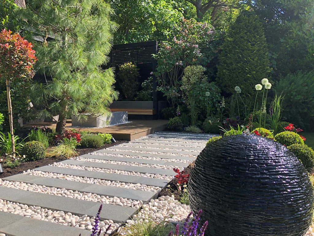 Path of Black Granite Plank Paving on cotnrasting pebbles.