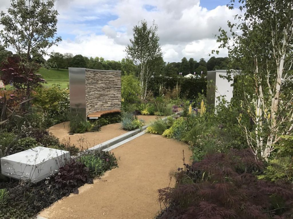 Show garden, RHS Chatsworth 2017, with buff self-binding gravel, Grey Yorkstone block, rill and curved stone-clad wall with bench.