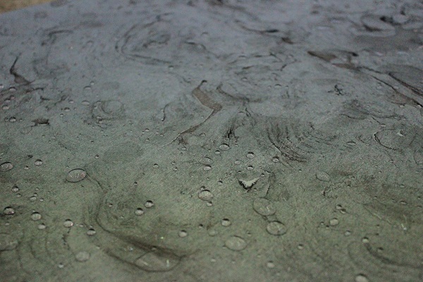 Close view of sawn limestone slab with water beading after it's been sealed.