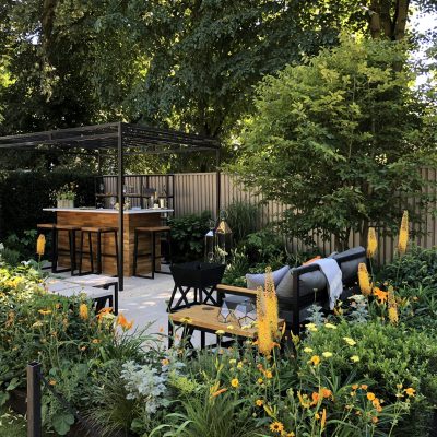 Jura Beige Limestone paves The Landform Garden Bar at RHS Hampton Court 2018. Stools at counter in background.