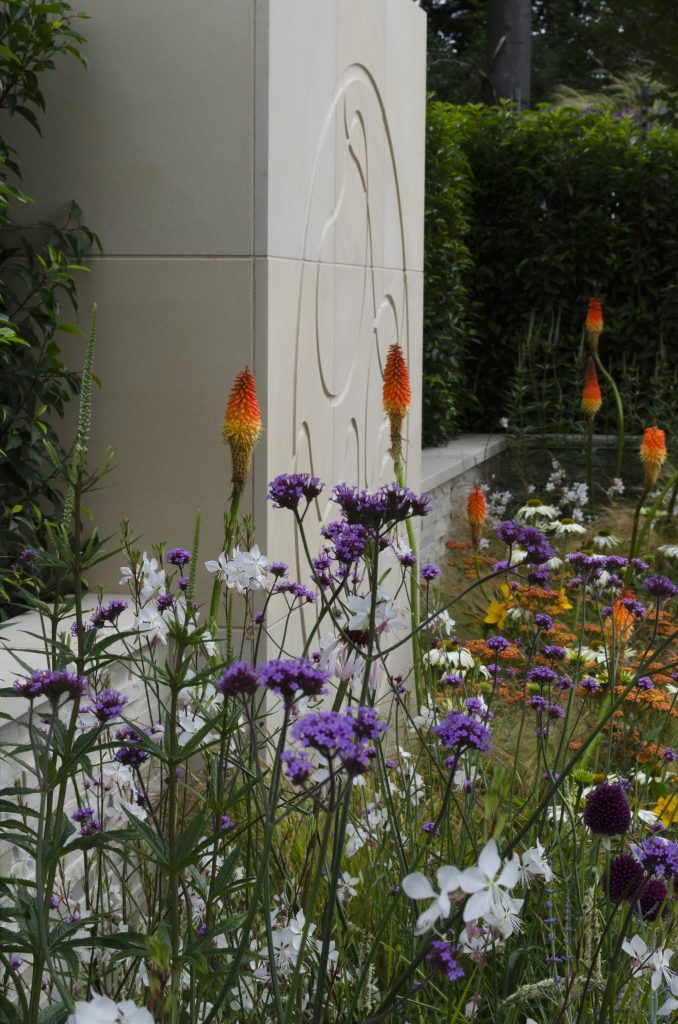 Wall of Harvest sawn sandstone slabs engraved by Bespoke Stone Centre in RHS Tatton park show garden by Kristian Reay.