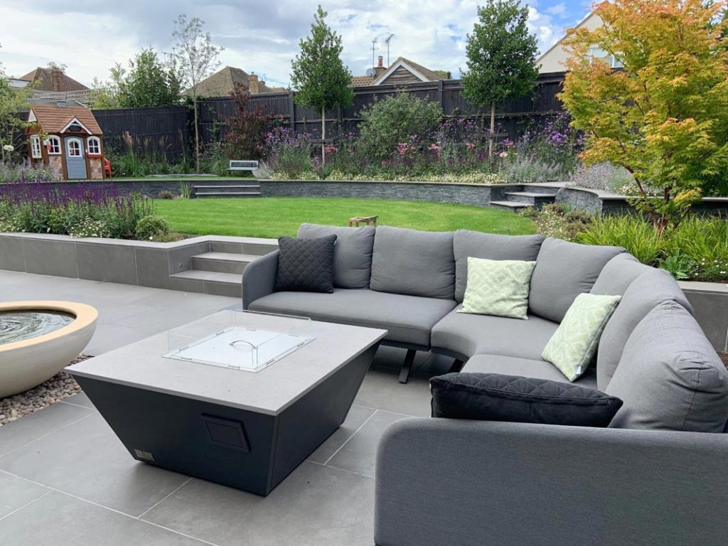 A stylish grey modular corner sofa and firepit make the perfect cosy spot. 