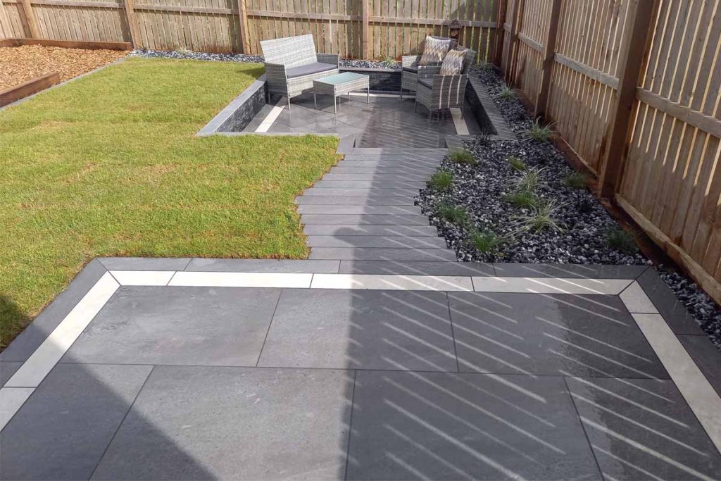 Light Grey and Steel Grey porcelain planks edge paved areas, linked by staggered path. 