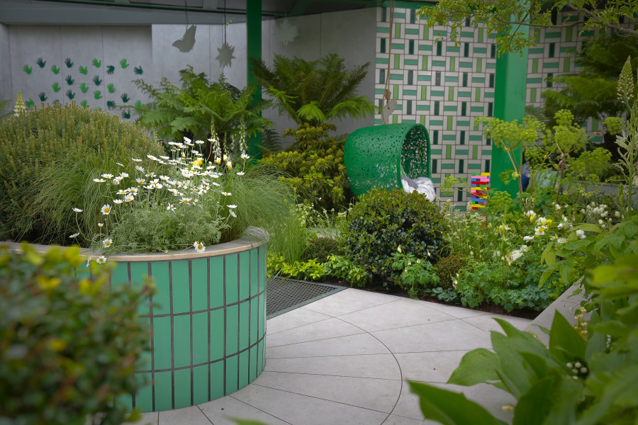 Florence Grey Porcelain is paired with green walling and seating and plenty of lush planting to make a bold contrast. 