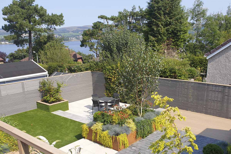 Peble Grey Composite Battens form perimeter of garden overlooking estuary view.