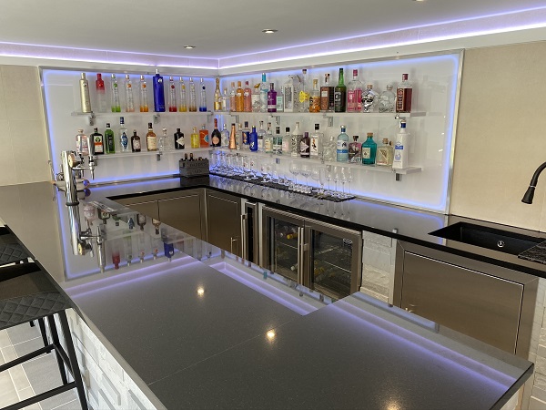 Home bar with, bottles and counter, rear walls of Desert Beige DesignClad cladding for interior walls.