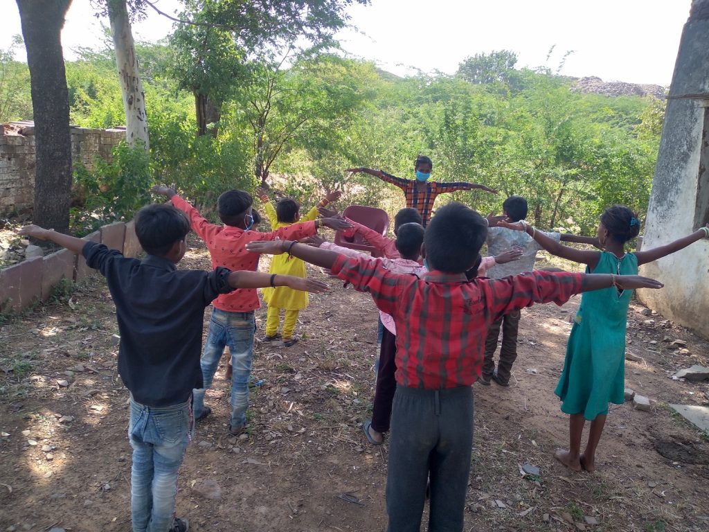 An adolescent girl leads a warm up session in the open air, before classes begin, in Budhpura, Rajasthan, India, No Child Left Behind