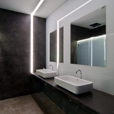 Mirror on light wall and Vulcano Roca porcelain bathroom cladding on washstand and adjacent wall.