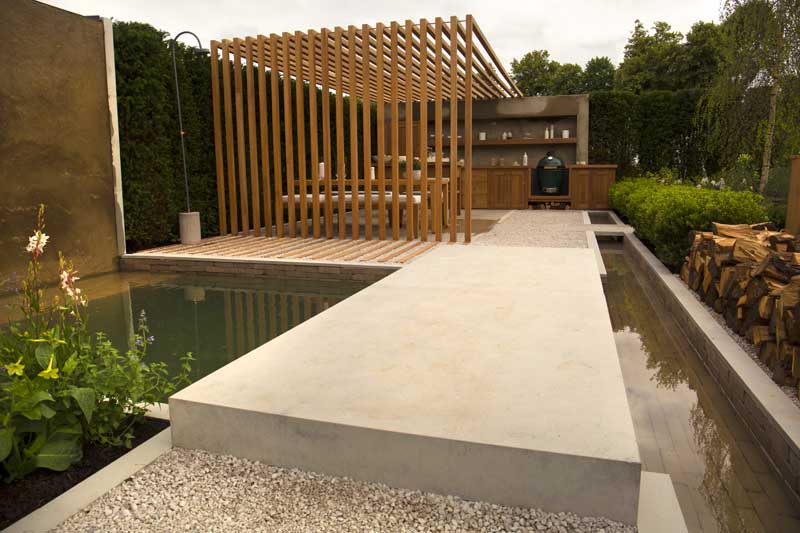 This bespoke Jura Grey Limestone bridge is paired with Gromo Antica clay pavers for a stunning result in this Hampton Court Palace Garden Festival 2021 garden. 