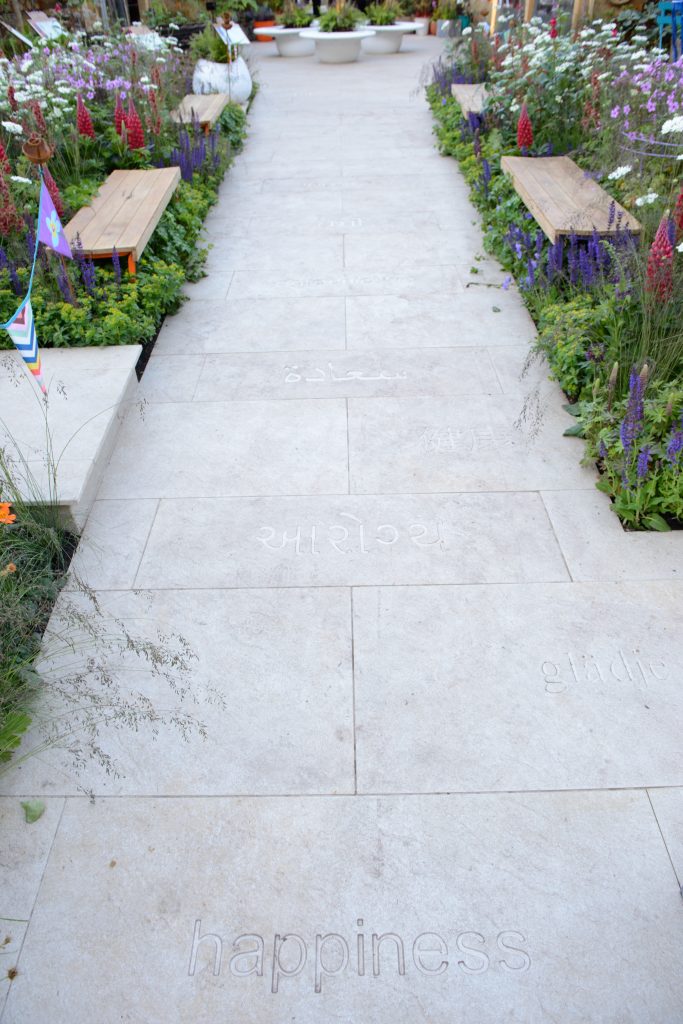 The word happiness is inscribed into Golden Stone Porcelain paving in various languages.
