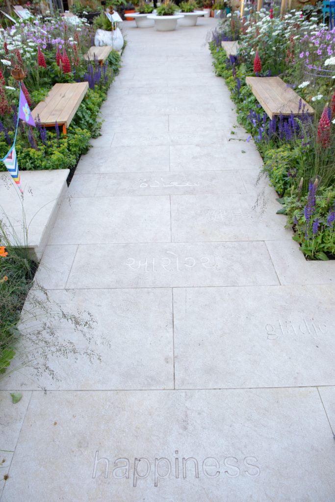 The word happiness is inscribed into Golden Stone Porcelain paving in various languages. 