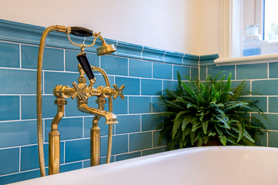 Marine blue gloss tiles splashback with chair rail tile and gold tap fittings from London Stone