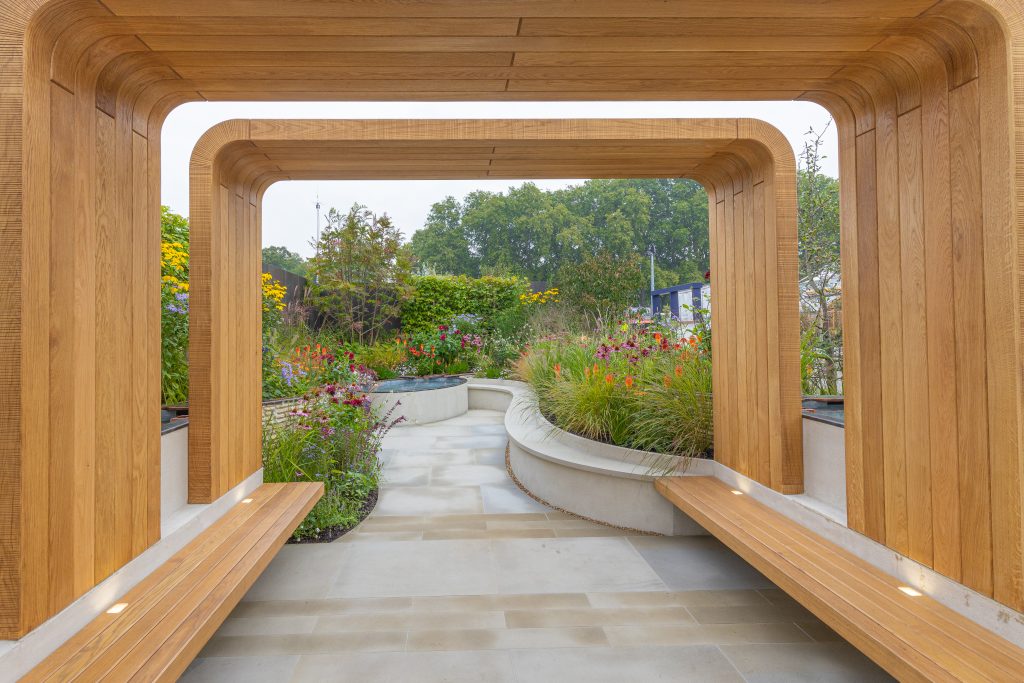 Heathermore Buff Yorkstone brightens the garden and perfectly complement the light wood arches and vibrant planting.