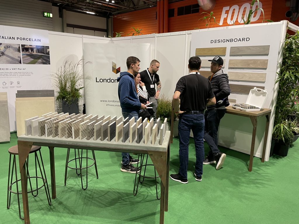 Porcelain samples are displayed on a table, behind London Stone staff members talk to customers at The Landscape Show. 