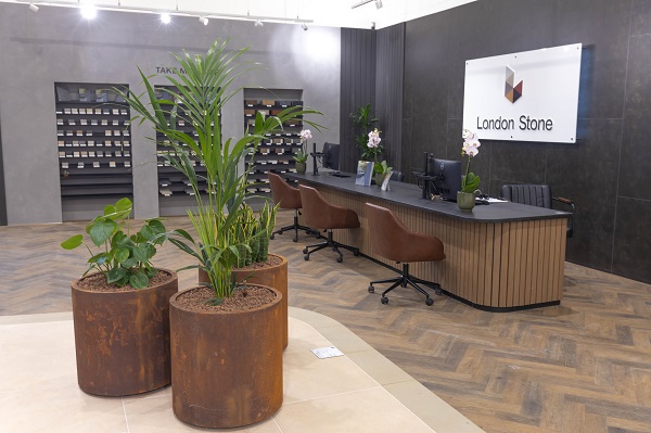 3 round corten steel planters, with plants, in display next to welcome desk, Hampshire showroom.