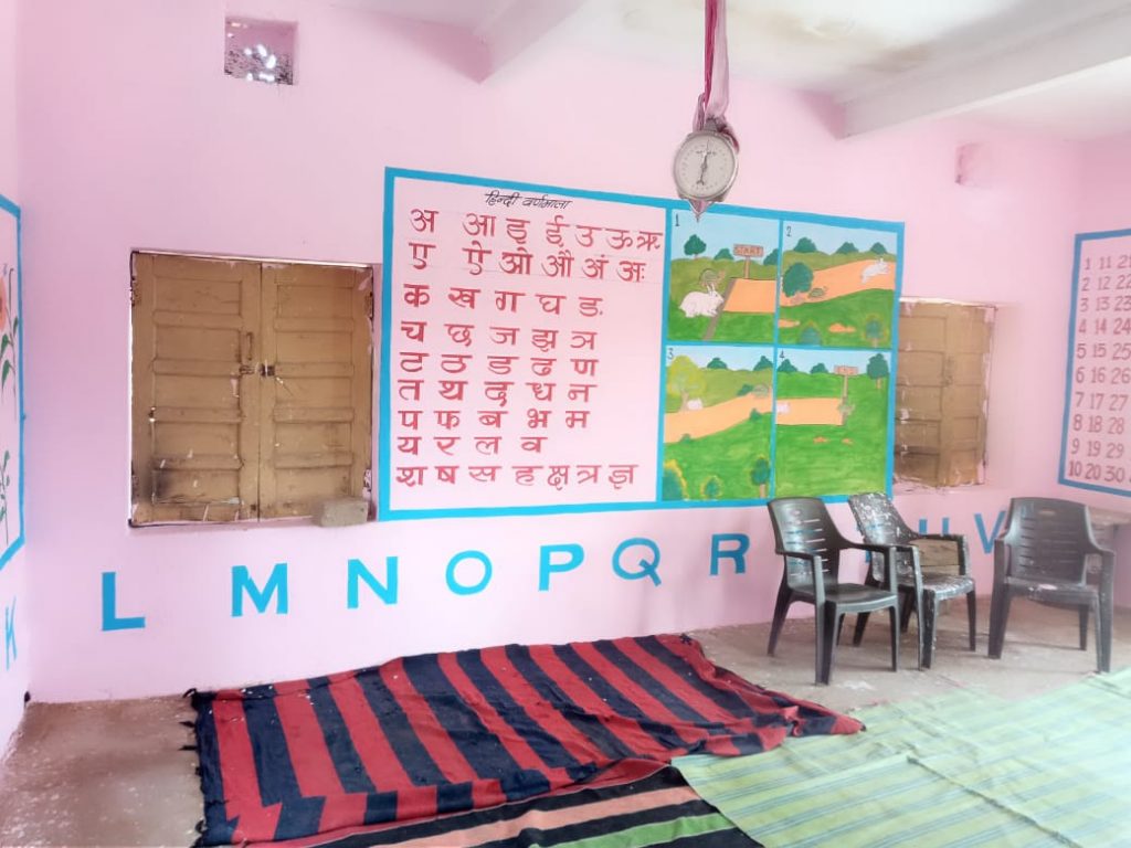 Interior of pink-walled room with numbers and letters painted on for educational purposes