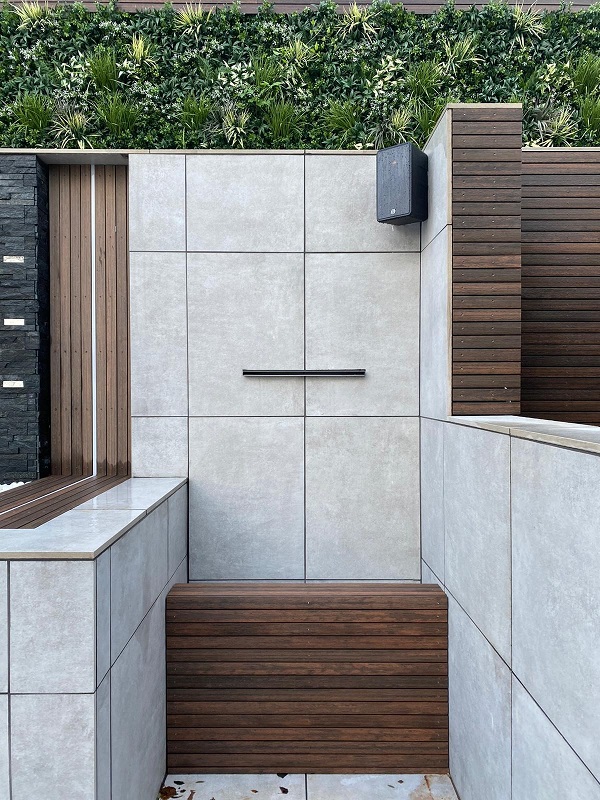 Chestnut composite battens contrast with white clad walls of outdoor storage area