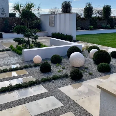 Patio paving of Harvest Sawn sandstone, gravel and cobbles, laid in stripes.
