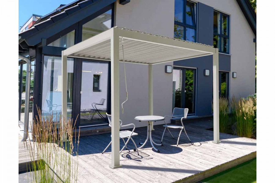 Proteus aluminium framed metal pergola on patio by house.