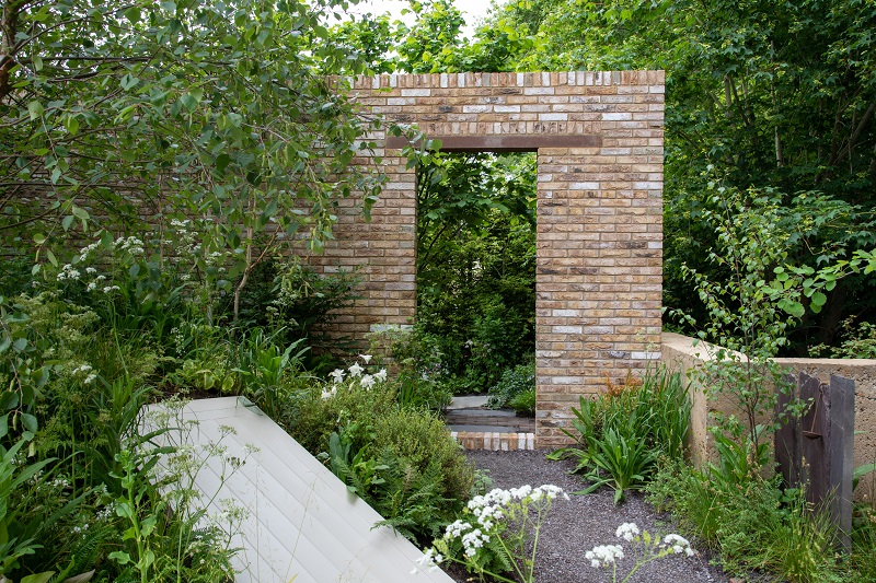 London Mixture Facing brick doorway with wild planting. Brewin Dolphin Garden. Design Paul Hervey-Brookes. RHS Chelsea 2022
