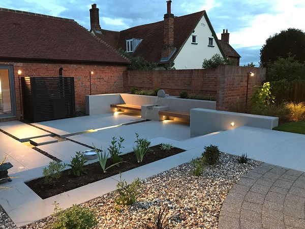 Patio with rill, water feature, beds and benches. Built by Habitat Landscapes, experts in porcelain paving.