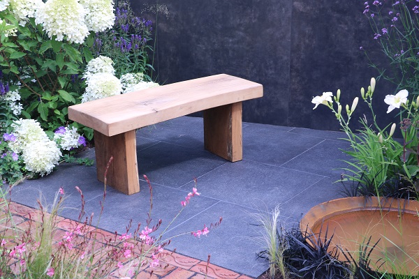 Black granite paving in Matt Haddon's A Place to Ponder garden, RHS Tatton Park 2018, with wooden bench and DesignClad walls.