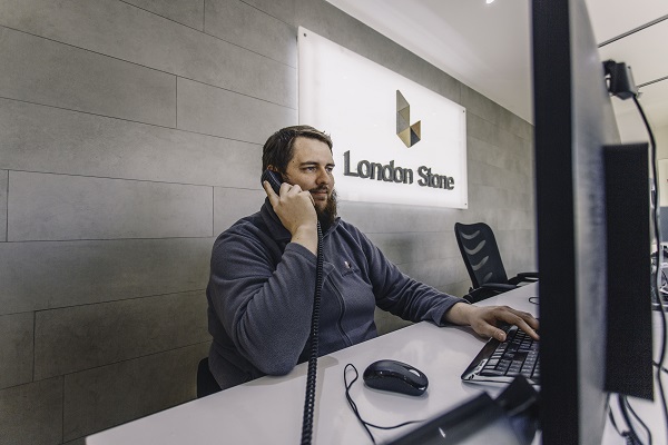 Manager at Middlesex showrrom sits in front of computer, on phone