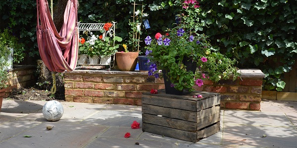 Autumn Brown Indian sandstone with brick raised bed, wooden planter and football.