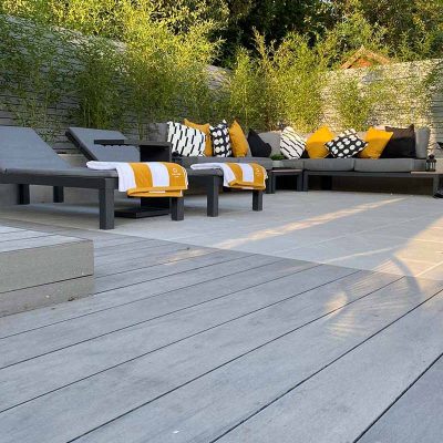 Pebble grey Designboard laid flush with porcelain paving. Sunloungers and outdoor sofa.