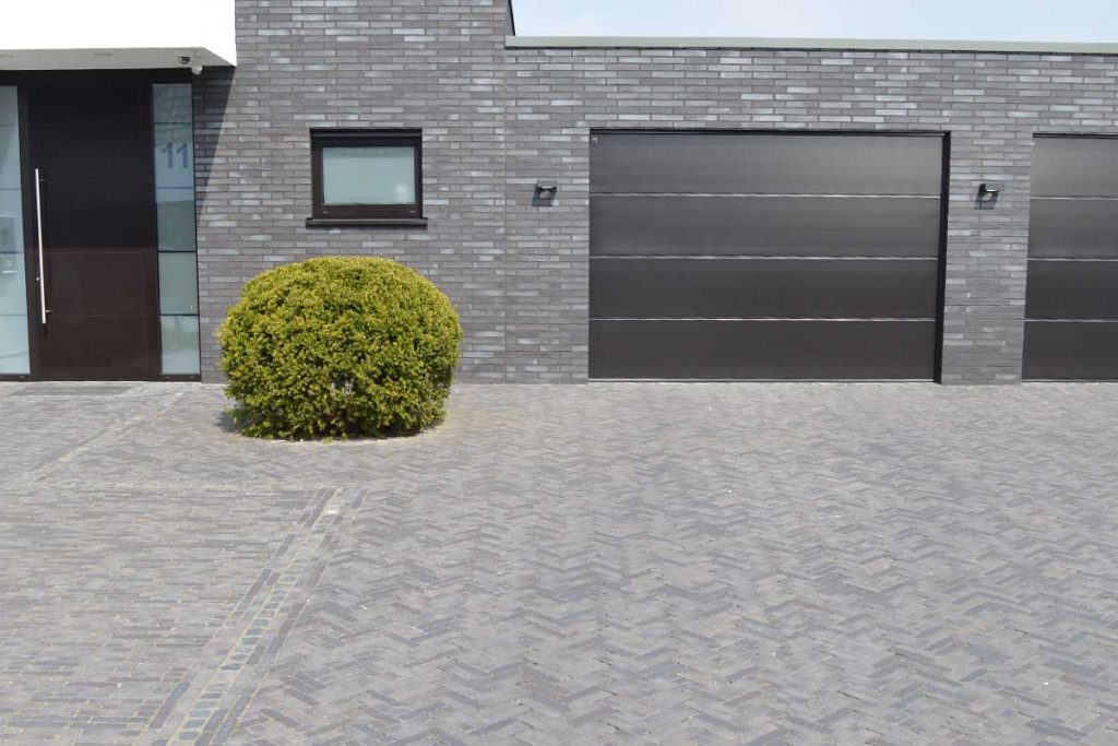 Carbona clay paving matches the grey brick of a modern, rectilinear garage frontage.
