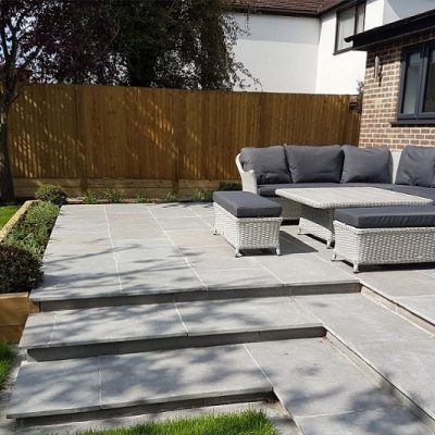 Graphite grey limestone paving patio and bullnose steps, with furniture.steps