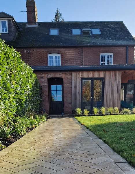 Straight path of Cream porcelain setts laid herringbone leads to back of house, between lawn and planted bed